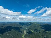 Luftaufnahme von üppig grünen Bergen und einem ruhigen Tal unter einem wolkenreichen Himmel, Kruth, Frankreich