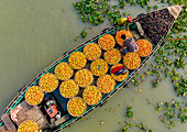 Dhaka,Bangladesh - 27 February 2023: Aerial view of people trading with fruits and vegetables on boats along the river in Dhaka,Bangladesh