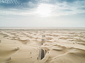 Abstrakte Luftaufnahme einer mit Sand bedeckten Straße in der Wüste, Abu Dhabi, UAE