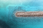 Aerial view of a barrier wall in the crystal clear blue ocean with patterns of rocks visible underneath the water,creating an abstract image,Dubai,Dubai,United Arab Emirates