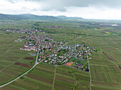 Luftaufnahme eines malerischen Dorfes, umgeben von grünen Feldern und Bergen, Kaysersberg, Frankreich