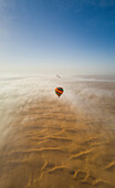 Aerial view of hot-air-balloon flying in the clouds of the Murqquab desert in Dubai,U.A.E