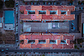 Aerial view of a building blocks in a residential city district with a football court on the side and cars all around,Camins al Grau,Valencia,Spain