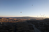 Aerial view of hot air balloons floating over a picturesque landscape at sunrise,Goreme,Turkey