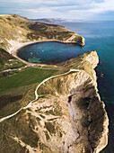 Luftaufnahme von Stair Hole mit Blick auf Lulworth Cove, Jurassic Coast im Hintergrund, Dorset, Vereinigtes Königreich