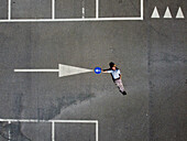 Aerial view of a person laying down on the ground with a signal road arrow,Arquata,Scrivia,Piedmont,Italy