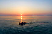 Luftaufnahme eines ruhigen Sonnenuntergangs über dem Meer mit der Silhouette eines Bootes, Baa Atoll, Malediven