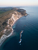 Luftaufnahme einer von türkisfarbenem Wasser umgebenen Bucht bei Durdle Door in West Lulworth, Wareham, UK