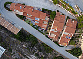 Aerial view of a lively townscape with organized architecture divided from a cliff by an asphalt road,Zona Encinas,Cumbre del Sol,Alicante,Spain