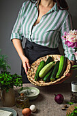 Woman presents bowl of fresh courgettes