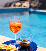 Aperol Spritz with green olives by the pool