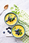 Sweet carrot soup with almond drink and blueberries