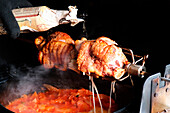 Basting grilled pork knuckles with beer