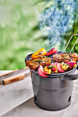 Vegetable and meat skewers on a mini grill