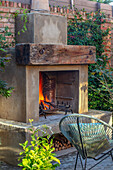 Gartenkamin, Stuhl und Backsteinmauer im Innenhofgarten