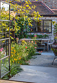 Blick auf den Innenhof mit Blumen und Gartenmöbeln