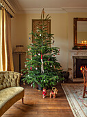 Weihnachtlich geschmückter Tannenbaum, Sofa und Kamin