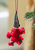 Rot-weißer Weihnachtsmann-Anhänger aus Garn und Filz am Tannenbaum