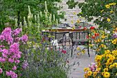 Sitzplatz auf der Terrasse, Bepflanzung mit Flammenblume, Duftnessel, Lavendel, Montbretie und Sonnenauge