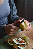 Woman peeling an apple with a knife