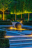 Moderner Garten mit beleuchtetem Wasserspiel und geometrischen Formen