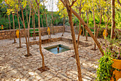 Rechteckiger Garten mit Teich, Akazien und grünen Bänken in Marokko