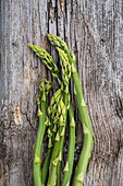 Grünspargel (Asparagus) auf rustikalem Holzuntergrund