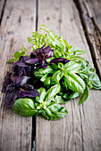 Frische Basilikumblätter auf einem Holztisch im Freien