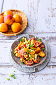 Vegan apricot and tomato salad with curry and peanut dressing