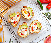 Baked eggs in bread with avocado and peppers