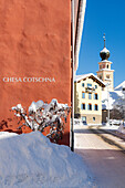 Clear winter sky on the alpine village of Madulain and old church covered with snow, Graubunden canton, Engadine, Switzerland