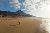 two guys admiring the beautiful landscape near to Cofete beach during a summer day, Natural Park de Jandia, Fuerteventura, Canary Island, Spain, Europe