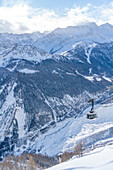 View of snow covered Aosta Valley, mountains and Skyway Monte Bianco cable car in winter, Courmayeur, Aosta Valley, Italian Alps, Italy