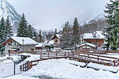 View of snow covered wooden houses and church in Entreves in winter, Entreves, Aosta Valley, Italian Alps, Italy