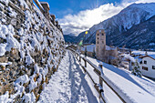 View of snow covered mountains, rooftops and Church of Saint Pantalon in Courmayeur in winter, Courmayeur, Aosta Valley, Italian Alps, Italy