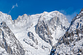 View of snow covered trees, mountains and Courmayeur from Dolonne in winter, Courmayeur, Aosta Valley, Italian Alps, Italy