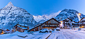 Blick auf Chalets und schneebedeckte Berge in Courmayeur vor der Morgendämmerung im Winter, Courmayeur, Aostatal, Italienische Alpen, Italien
