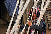 Woman making weaving warp, from Akha Puli tribe living in village in the mountains surrounding Muang La, Oudomxay Province, northwestern Laos
