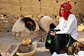 Woman cooking bread in a traditional Berber oven, Atlas Kasbah, guesthouse, near Agadir,Morocco