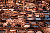 Rows of dye-filled stone basins in a traditional leather tannery in Fes, Morocco