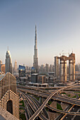 Dubai skyline at sunset with Burj Khalifa, the world tallest building and Sheikh Zayed road traffic, Dubai, United Arab Emirates
