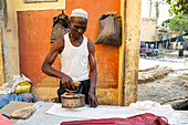 Man ironing with coal heated iron, Kofar Mata Dye Pits, Kano, Nigeria