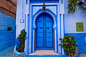 Schön verzierte blaue Eingangstür in den blau gefärbten Straßen von Chefchaouen, Marokko