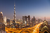 Dubai skyline at sunset with Burj Khalifa, the world tallest building and Sheikh Zayed road traffic, Dubai, United Arab Emirates
