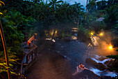 Heiße Quellen aus dem Arenal Vocano im Tabacón Grand Spa, Costa Rica. Ein Besucher genießt einen der warmen Bäche, die durch das Tabacon Hot Spring Resort and Spa in Costa Rica fließen