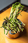 Bunches of wild asparagus resting in a pot, prepared for cooking, captivating and fresh.