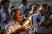 Castilleja, Spain, Aug 11 2024, A musician plays a tuba during an outdoor performance in Castilleja del Campo, creating a lively atmosphere under the night sky.