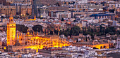 A stunning aerial view of Seville with iconic Giralda and Cathedral illuminated at twilight.