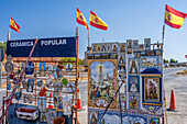 Outdoor ceramics booth showcasing Spanish handcrafts and religious tile artworks on display.