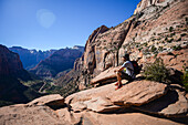 Young caucasian man in canyon overlook trail, admiring the landscape view, Zion National Park, Utah